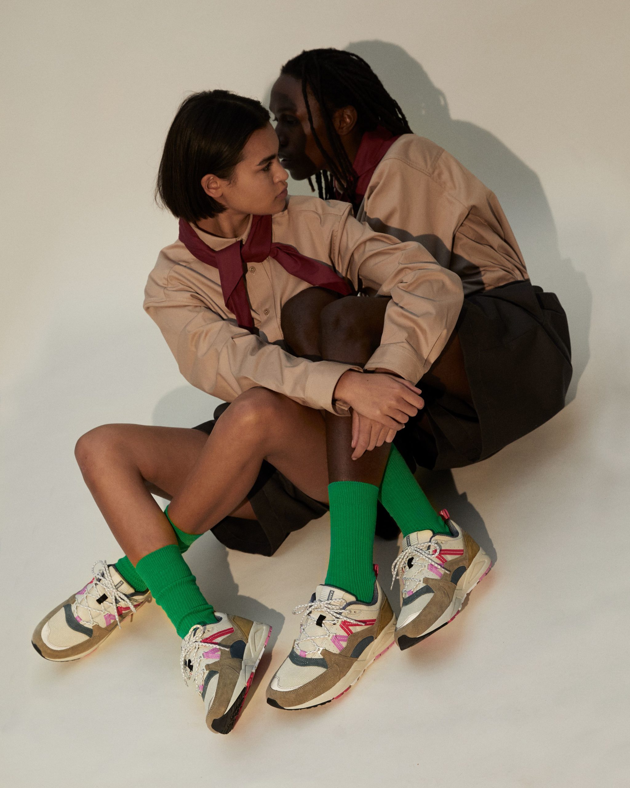Karhu sneakers terwijl twee modellen dichtbij elkaar zitten