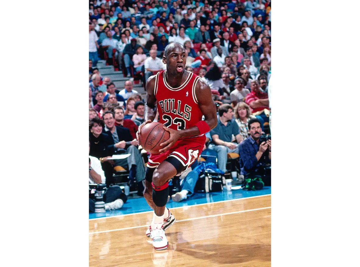 Michael Jordan loopt op de basket af in zijn Air Jordan 4 White/Fire Red-Black