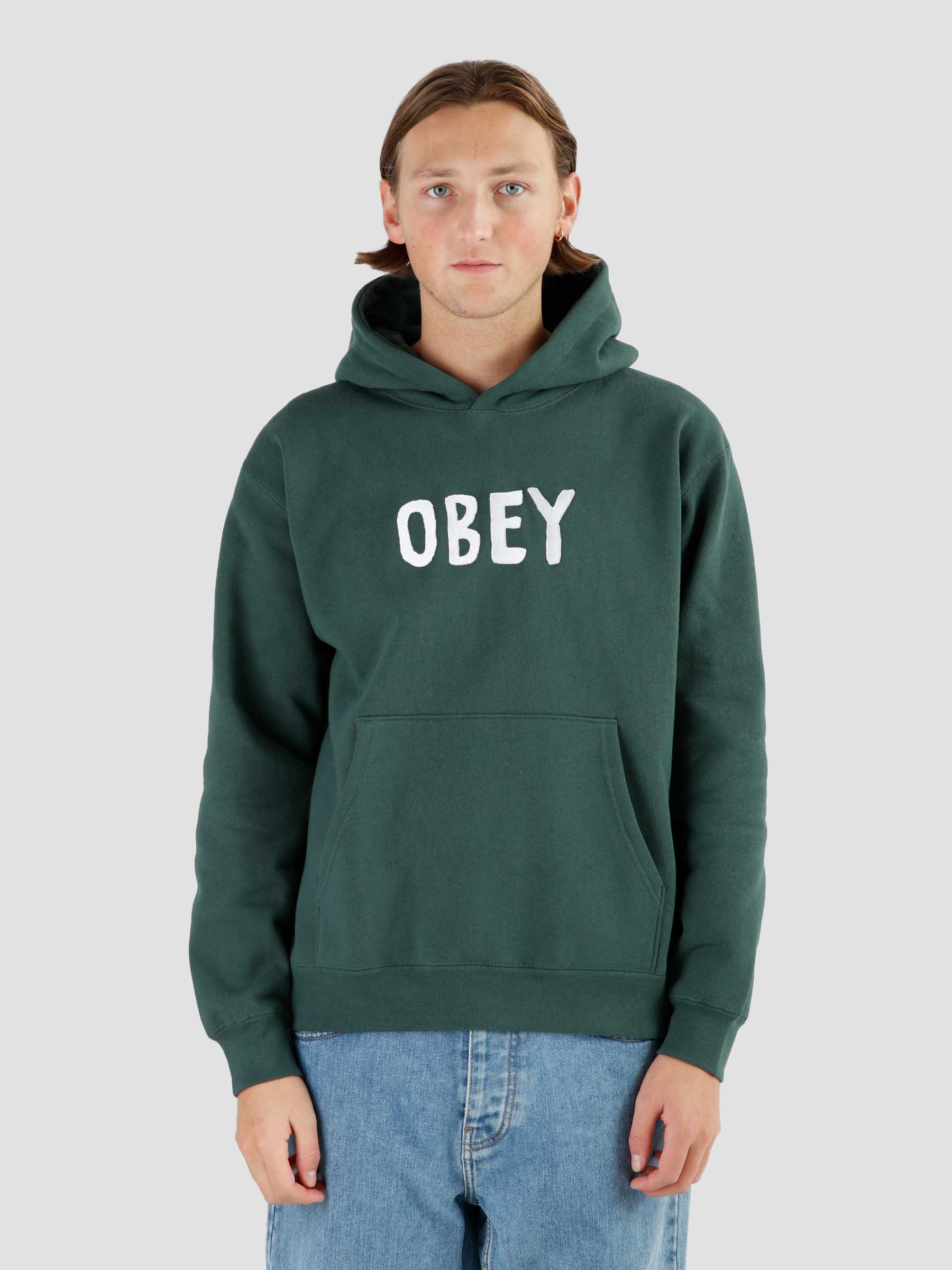 Man draagt Obey Og Type Extra Hoodie Dark Cedar