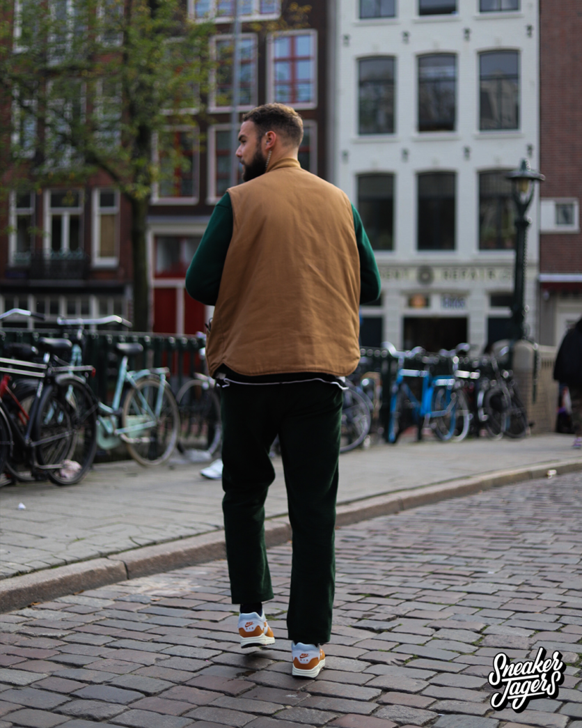 outside patta amsterdam for patta x nike air max 1 monarch the wave release - man walking away in sneakers